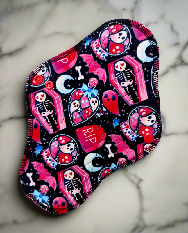 Ghostion soft pinks and bold reds with ghosts trapped in potions along with motifs of coffins and bats.