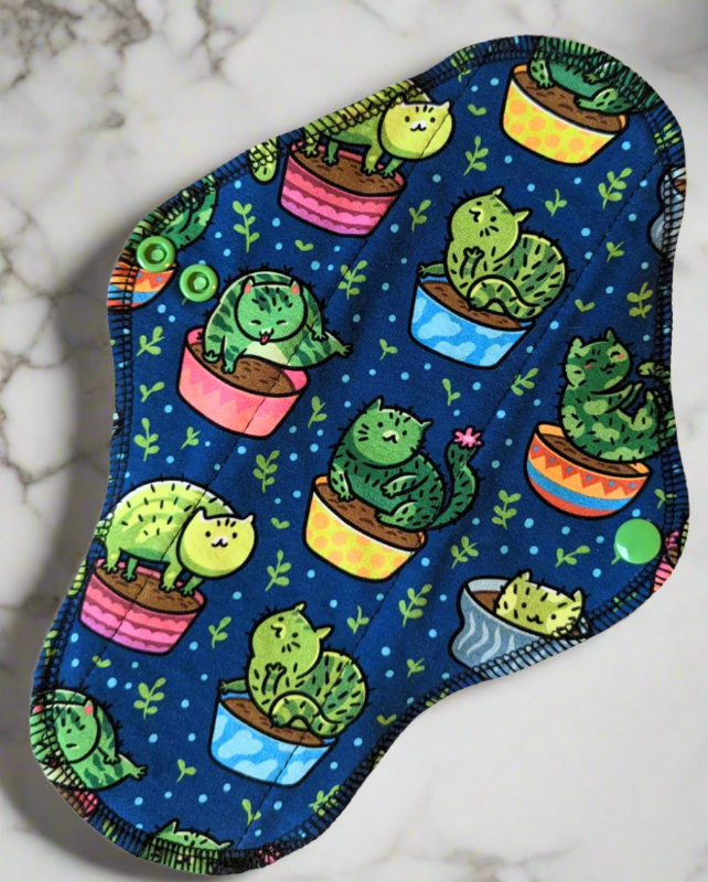 Cactus Cats -cotton spandex Cactus cats planted in pots on a blue background with green leaf's. Each planted cat is in a different position