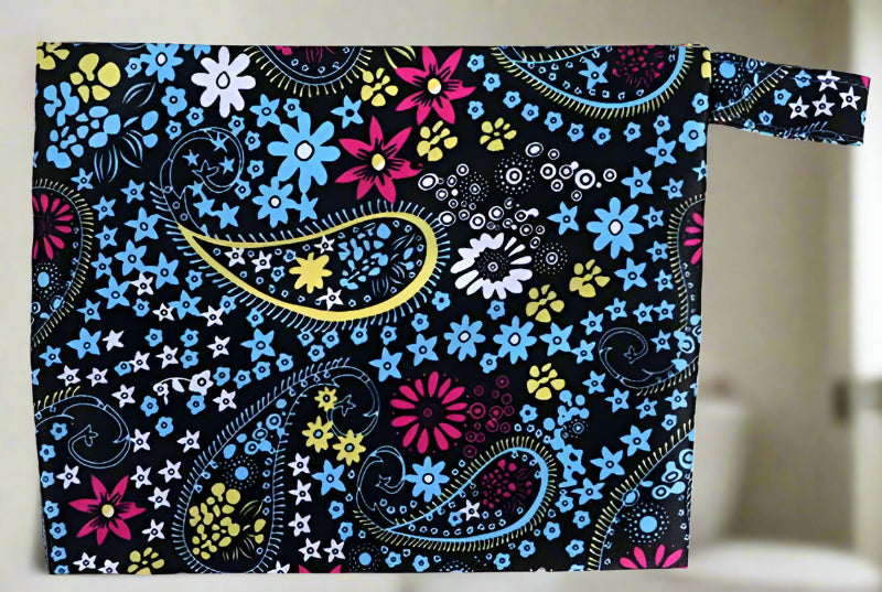 Mini wet bag featuring a paisley and flower print on a black background, perfect for storing small cloth pads, swimwear, or other essentials. Waterproof and compact design.