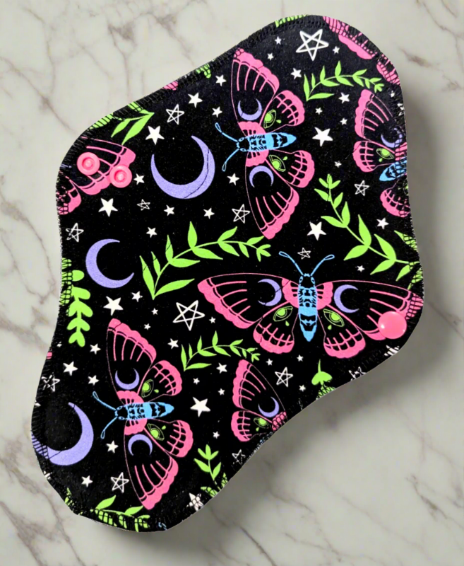 Electric moth black background, pink and blue months, green foliage, purple moons, and white stars.