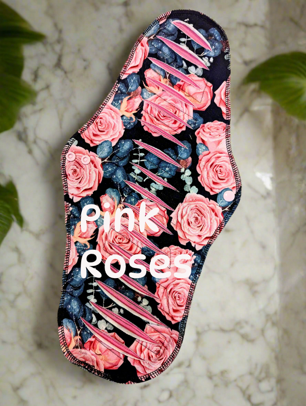 Black background bright pink roses with greeny blue foliage