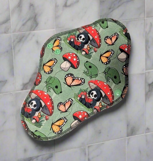 Reaper Mushroom -Reaper sitting under mushroom reading with frogs and butterflies on a green background