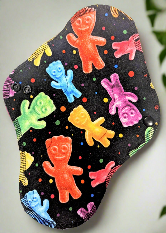 Sweet Treats - Cotton Spandex -  sweet and sour little men candies on black background with muti coloured dots