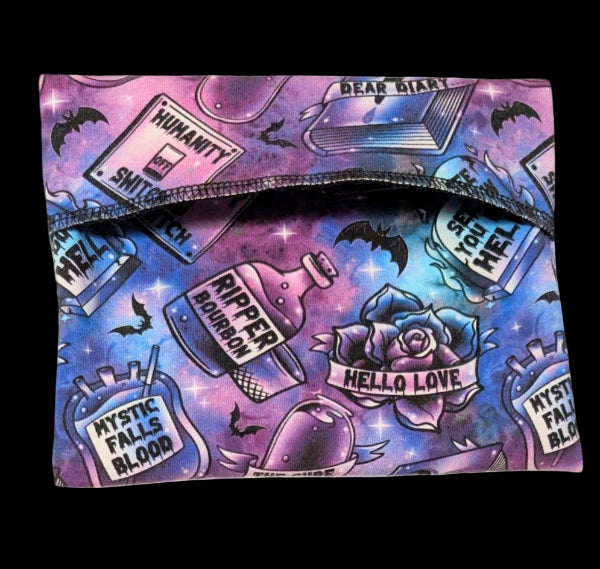 Colorful pouch with tvd-themed design featuring text and graphics on a pink & blue background